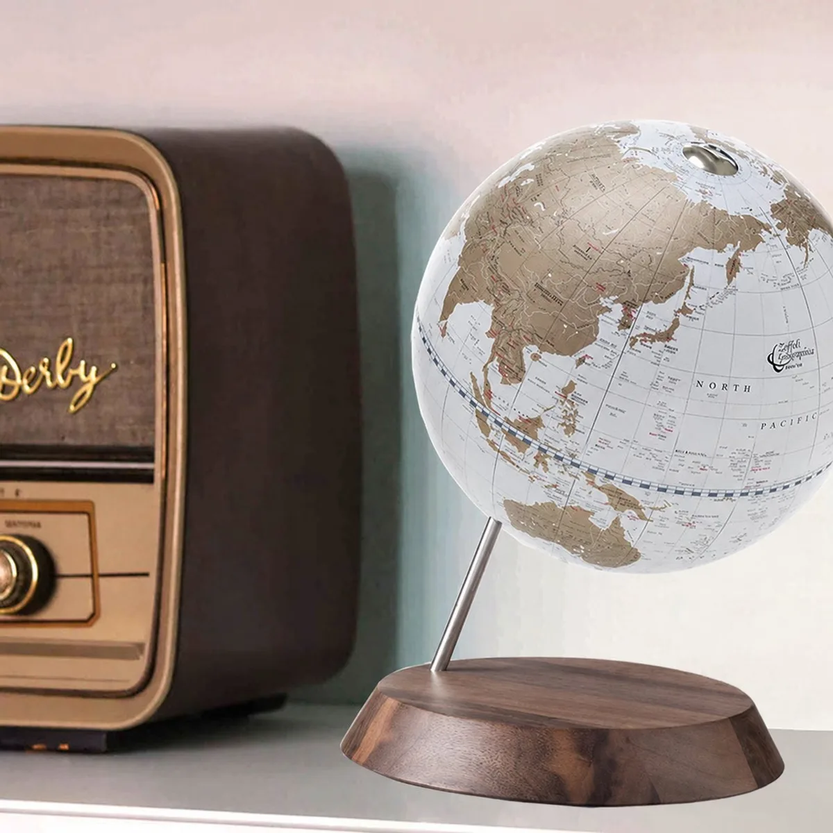 Globe Zoffoli Desk Oro à carte blanche et dorée, posé près d'une radio ancienne